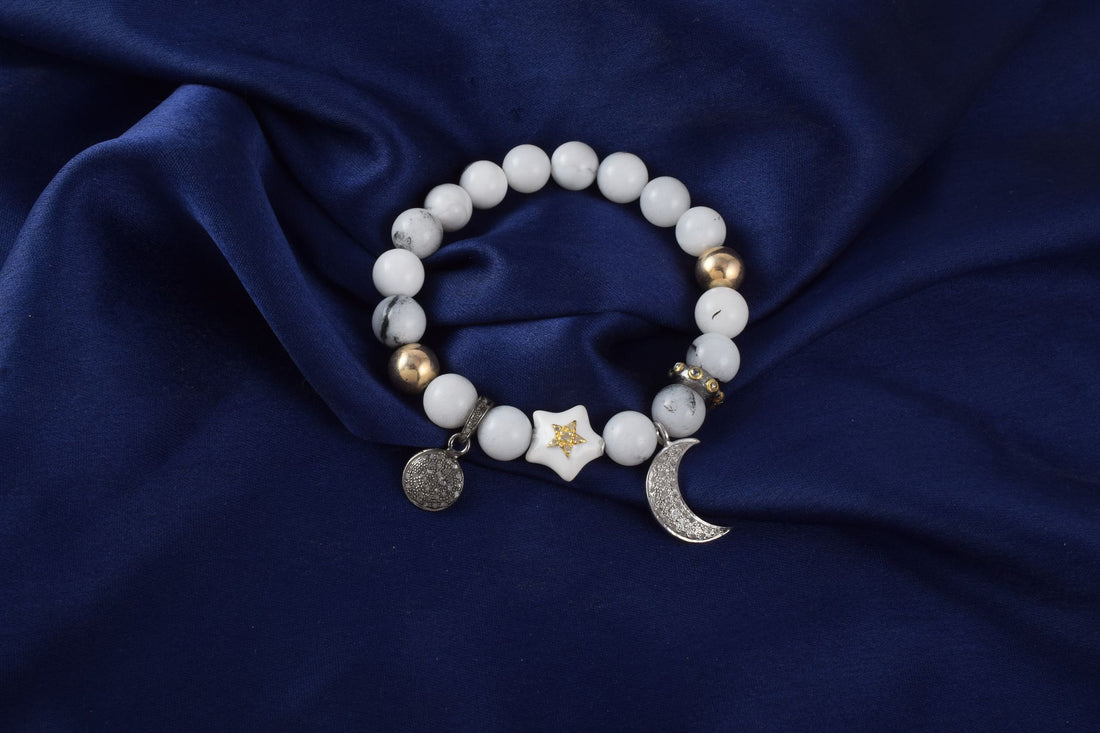 White howlite and deep blue lapis lazuli beads resting on grey linen in soft light
