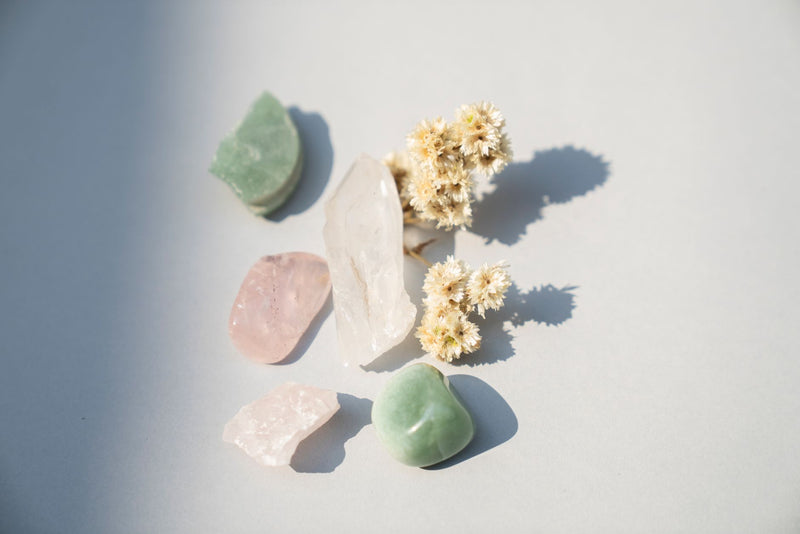 Pale pink rose quartz and clear quartz crystals resting on natural linen