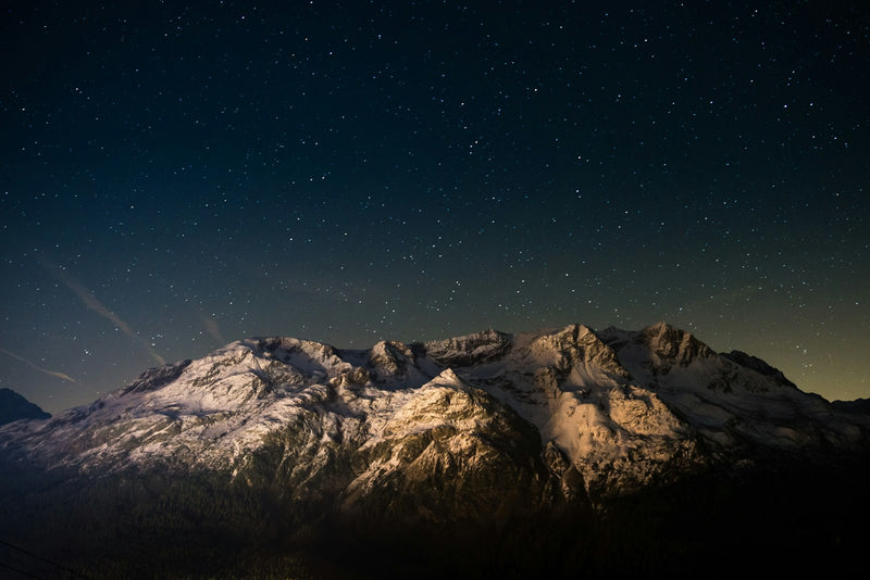 Night sky with a small bright planet visible above the horizon