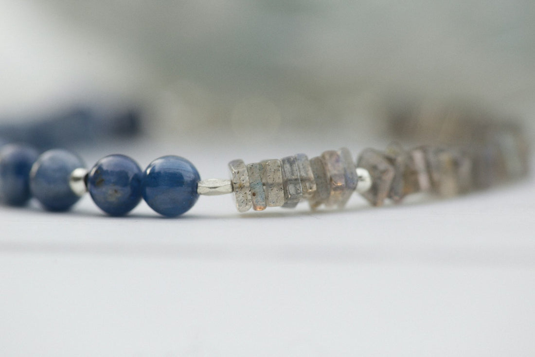 Brown smoky quartz beads strung with deep blue lapis lazuli on pale wood